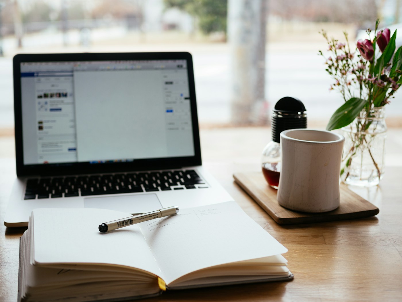 Open notebook and pen on a calm desk by a window